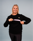 Happy active mother wearing pregnancy jumper and showing nursing zip functionality 