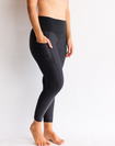 Active mum showing the belly band support pulled down on the black maternity leggings
